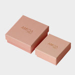 Two pink Amica Jewels gift boxes on a white background.