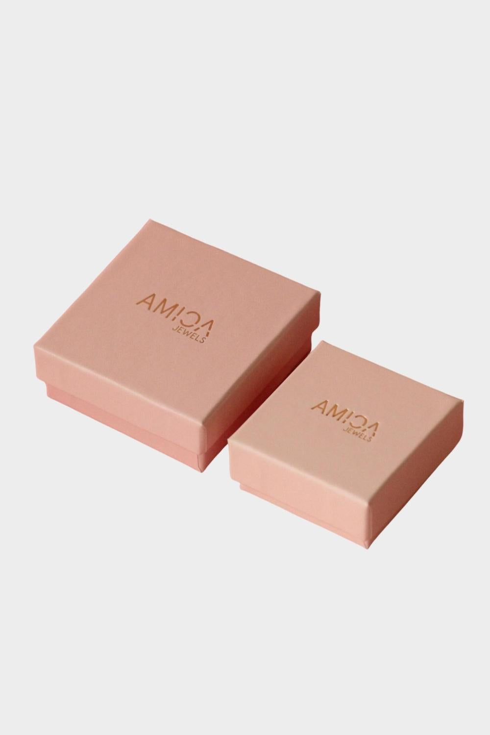 Two pink Amica Jewels gift boxes on a white background.