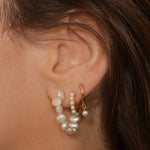 Beaded pearl hoop earrings in 18k gold plated silver. The earrings feature a classic hoop design adorned with delicate beads and lustrous pearls. The gold plated silver adds a touch of elegance and sophistication to the design. The pearls are beautifully strung along the hoops, adding a timeless and glamorous element.