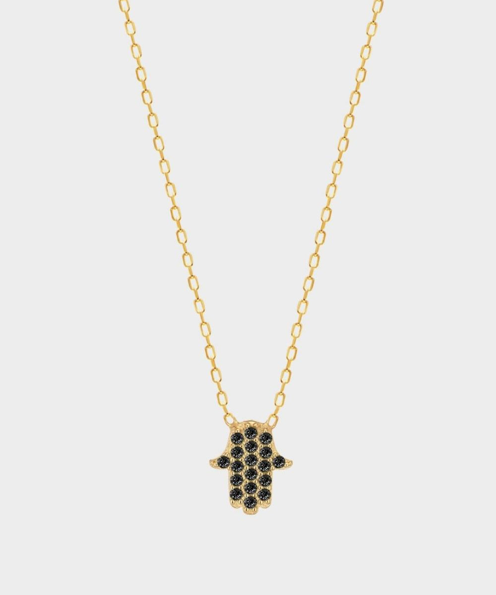 a black Hamsa hand charm necklace in 18k gold plated silver. The necklace features a delicate chain with a beautifully designed Hamsa hand charm pendant.  The Hamsa hand symbol is believed to bring protection, good luck, and ward off evil. The necklace is designed to be worn comfortably and can be adjusted to fit different neck sizes.