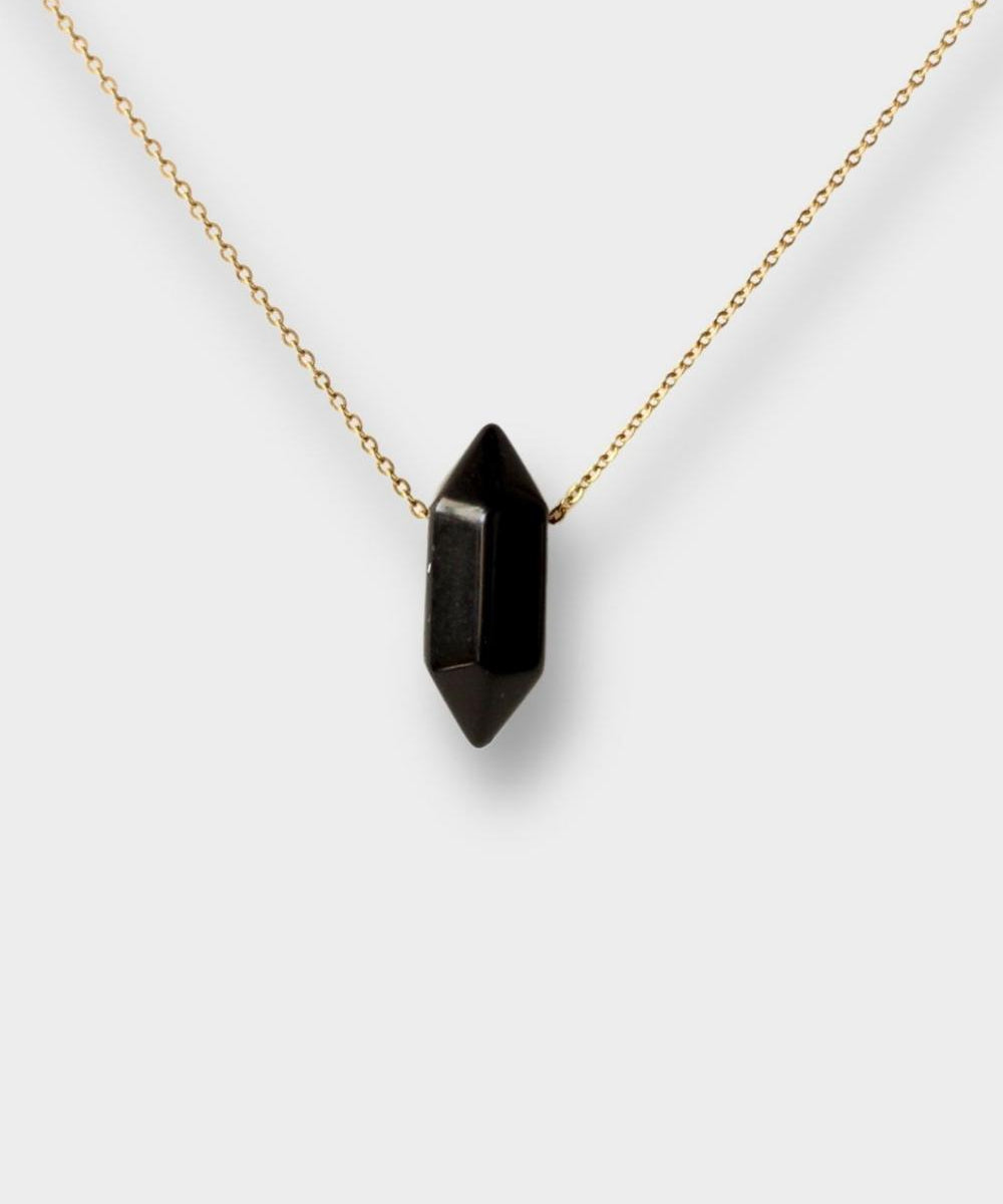 Black obsidian crystal necklace. The necklace features a pointed black obsidian crystal pendant attached to a gold chain, creating a stunning and eye-catching piece of jewelry.