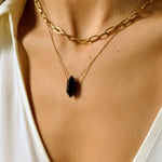 Black obsidian crystal necklace. The first necklace features a pointed black obsidian crystal pendant, while the second necklace features a delicate gold paper clip chain. Together, the necklaces create a stunning layered look that adds sophistication and elegance to any outfit.