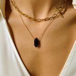 Black obsidian crystal necklace. The first necklace features a pointed black obsidian crystal pendant, while the second necklace features a delicate gold paper clip chain. Together, the necklaces create a stunning layered look that adds sophistication and elegance to any outfit.