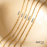 Five gold chains labeled Style 1 to Style 5 on a beige surface with 'AMIGA JEWELS' branding.