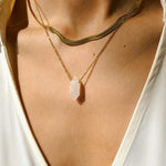 Clear Quartz crystal necklace. The first necklace features a pointed clear quartz crystal pendant, while the second necklace features a delicate gold snake chain. Together, the necklaces create a stunning layered look that adds sophistication and elegance to any outfit.