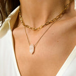 Clear Quartz crystal necklace. The first necklace features a pointed clear quartz crystal pendant, while the second necklace features a delicate gold paper clip chain. Together, the necklaces create a stunning layered look that adds sophistication and elegance to any outfit.