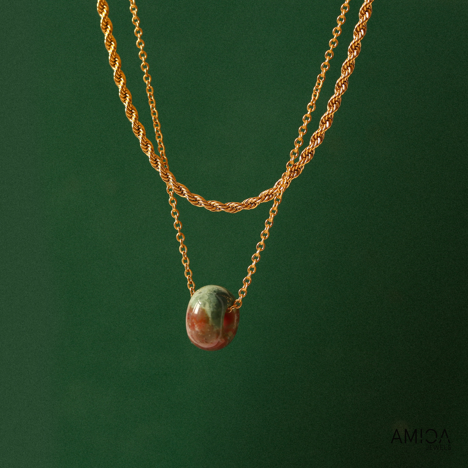 Gold necklace with a pendant on a green background
