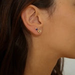 Evil eye stud earrings in 18k gold plated. The earrings feature a traditional evil eye design with a vibrant blue center. The evil eye symbol is believed to provide protection against negative energy and bring good luck. The studs are made of high-quality gold plated material with a polished finish, giving them a luxurious and elegant look.