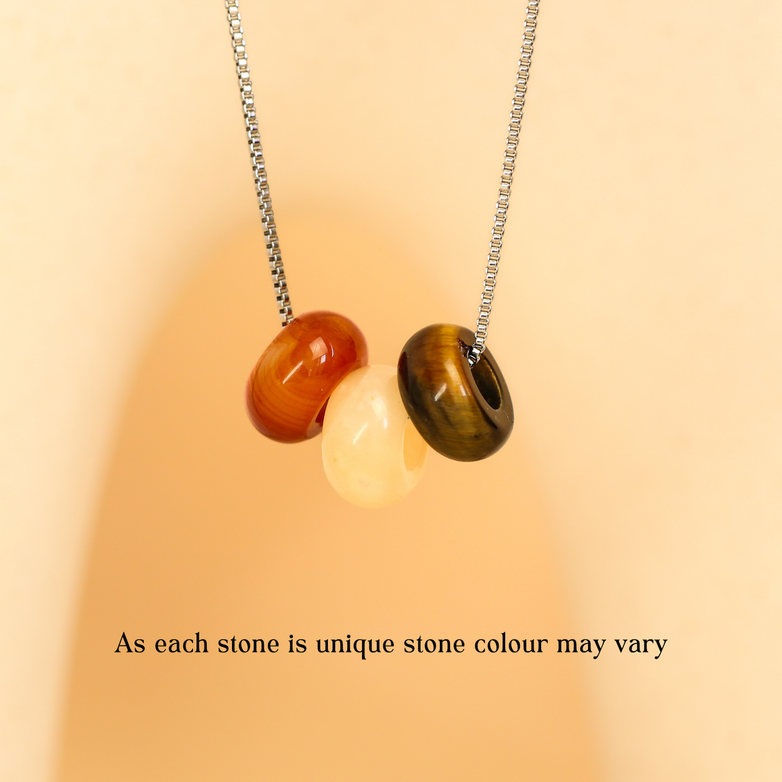 Necklace with three unique stones on a beige background