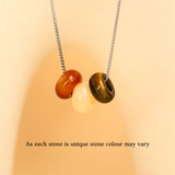 Necklace with three unique stones on a beige background