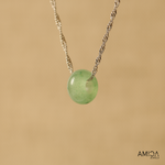 Necklace with a green pendant on a beige background, featuring the brand 'AMICA JEWELS'.