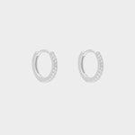 diamond huggie hoops in sterling silver. The earrings feature a classic huggie-style design adorned with sparkling diamonds. The diamonds are meticulously set along the front of the hoops, adding a touch of luxury and glamour. The hoops are made of high-quality silver and have a polished finish.