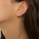 diamond huggie hoops in 18k gold plated silver. The earrings feature a classic huggie-style design adorned with sparkling diamonds. The diamonds are meticulously set along the front of the hoops, adding a touch of luxury and glamour. The hoops are made of high-quality gold plated silver and have a polished finish.