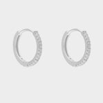 diamond huggie hoops in sterling silver. The earrings feature a classic huggie-style design adorned with sparkling diamonds. The diamonds are meticulously set along the front of the hoops, adding a touch of luxury and glamour. The hoops are made of high-quality  silver and have a polished finish.