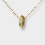 Labradorite crystal necklace. The necklace features a pointed labradorite crystal pendant attached to a gold chain, creating a stunning and eye-catching piece of jewelry.