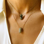 Labradorite crystal necklace. The necklace features a pointed labradorite crystal pendant attached to a gold chain, creating a stunning and eye-catching piece of jewelry.