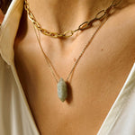 Labradorite crystal necklace. The first necklace features a pointed labradorite crystal pendant, while the second necklace features a delicate gold paper clip chain. Together, the necklaces create a stunning layered look that adds sophistication and elegance to any outfit.