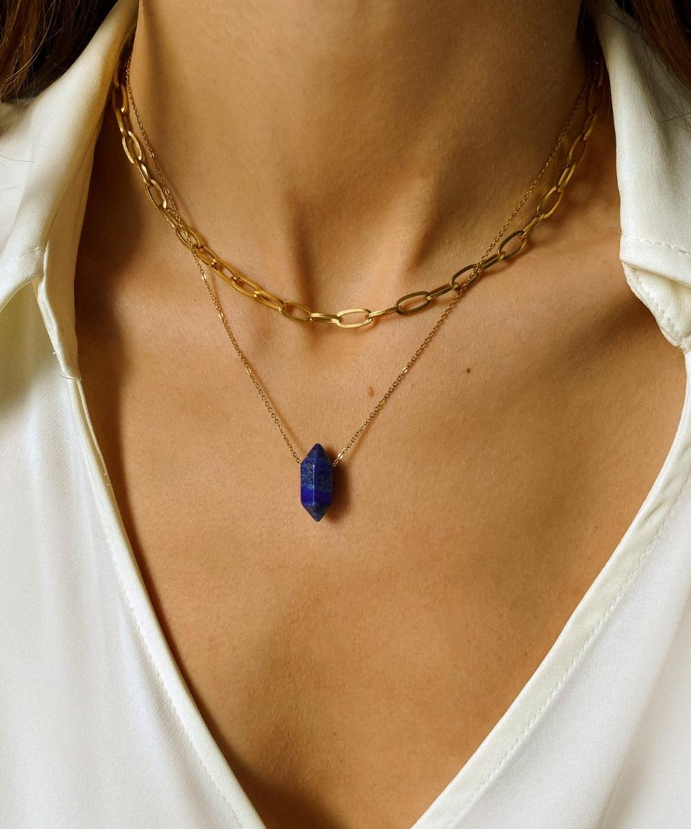 Natural Lapis lazuli crystal necklace. The first necklace features a pointed lapis lazuli crystal pendant, while the second necklace features a delicate gold paper clip chain. Together, the necklaces create a stunning layered look that adds sophistication and elegance to any outfit.