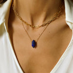 Natural Lapis lazuli crystal necklace. The first necklace features a pointed lapis lazuli crystal pendant, while the second necklace features a delicate gold paper clip chain. Together, the necklaces create a stunning layered look that adds sophistication and elegance to any outfit.