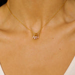 An initial pendant necklace in 18k gold plated silver. The necklace features a delicate gold chain, with a pendant in the shape of a single letter N and H from the alphabet. The pendant is intricately designed, showcasing the initial with a stylish and elegant font. Perfect for gifting or adding a personal touch to any outfit.
