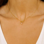 An initial pendant necklace in 18k gold plated silver. The necklace features a delicate gold chain, with a pendant in the shape of a single letter T from the alphabet. The pendant is intricately designed, showcasing the initial with a stylish and elegant font. Perfect for gifting or adding a personal touch to any outfit.