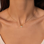 An initial pendant necklace in 18k gold plated silver. The necklace features a delicate gold chain, with a pendant in the shape of a single letter M from the alphabet. The pendant is intricately designed, showcasing the initial with a stylish and elegant font. Perfect for gifting or adding a personal touch to any outfit.