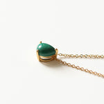 A malachite stone pendant necklace in 18k gold plated silver. The necklace features a stunning malachite stone pendant that is beautifully crafted and set in a gold bezel. The malachite stone exhibits vibrant shades of green with unique patterns, creating a captivating and natural look. The pendant is suspended from a delicate gold chain, adding elegance and sophistication to the necklace