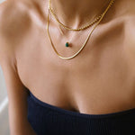 A malachite stone pendant necklace in 18k gold plated silver. The necklace features a stunning malachite stone pendant that is beautifully crafted and set in a gold bezel. The malachite stone exhibits vibrant shades of green with unique patterns, creating a captivating and natural look. The pendant is suspended from a delicate gold chain, adding elegance and sophistication to the necklace