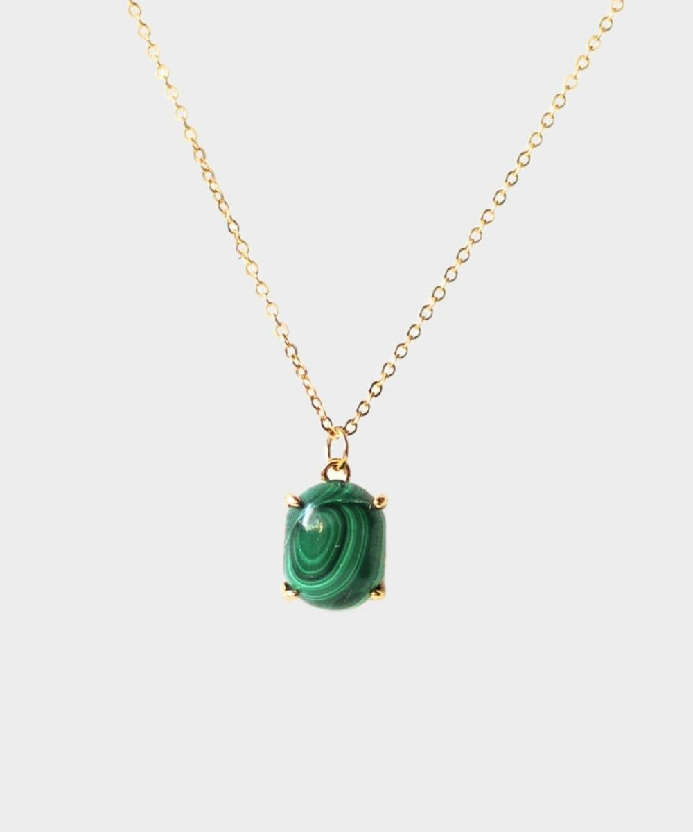 A malachite stone pendant necklace in 18k gold plated silver. The necklace features a stunning malachite stone pendant that is beautifully crafted and set in a gold bezel. The malachite stone exhibits vibrant shades of green with unique patterns, creating a captivating and natural look. The pendant is suspended from a delicate gold chain, adding elegance and sophistication to the necklace