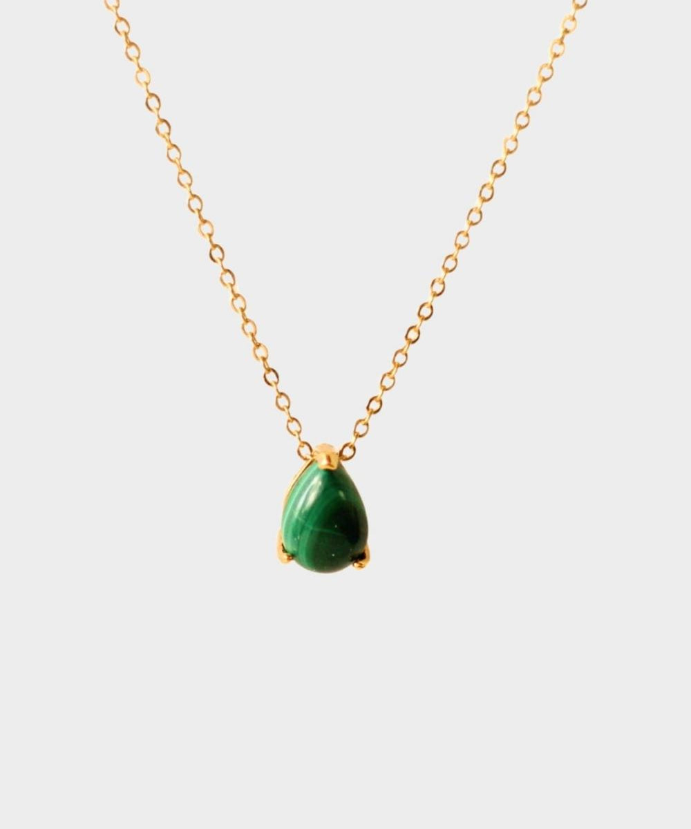 A malachite stone pendant necklace in 18k gold plated silver. The necklace features a stunning malachite stone pendant that is beautifully crafted and set in a gold bezel. The malachite stone exhibits vibrant shades of green with unique patterns, creating a captivating and natural look. The pendant is suspended from a delicate gold chain, adding elegance and sophistication to the necklace