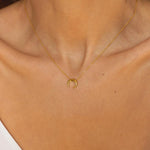 A moon necklace in 18k gold plated silver. The necklace features a delicate gold  chain with a pendant in the shape of a crescent moon. The necklace is perfect for those who love celestial-inspired jewelry, and makes for an elegant and stylish accessory that can be worn on any occasion.