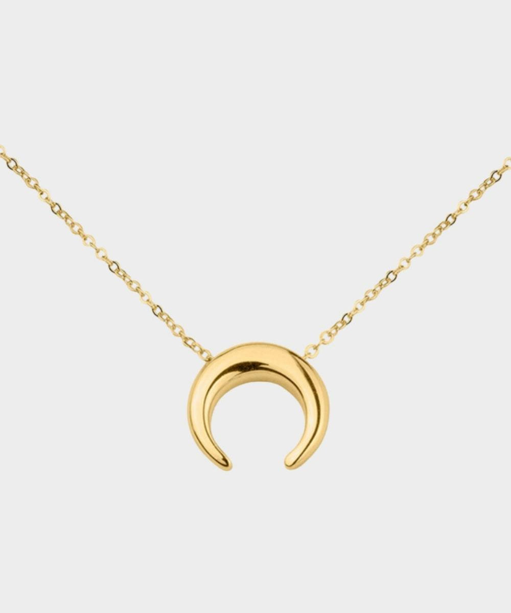 A moon necklace in 18k gold plated silver. The necklace features a delicate gold chain with a pendant in the shape of a crescent moon. The necklace is perfect for those who love celestial-inspired jewelry, and makes for an elegant and stylish accessory that can be worn on any occasion.