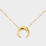 A moon necklace in 18k gold plated silver. The necklace features a delicate gold chain with a pendant in the shape of a crescent moon. The necklace is perfect for those who love celestial-inspired jewelry, and makes for an elegant and stylish accessory that can be worn on any occasion.