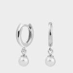 Drop pearl huggies in sterling silver. The earrings feature a huggie-style design with drop-shaped pearls. The pearls are lustrous and elegantly suspended from the gold plated silver hoops. The hoops have a sleek and polished finish. These earrings are versatile and can be worn for both casual and formal occasions