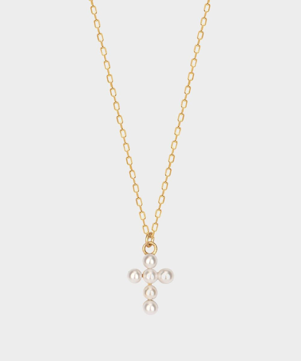 Pearl cross pendant necklace in 18k gold plated silver. The necklace features a delicate gold-plated silver chain with a pendant in the shape of a cross. The cross pendant is adorned with lustrous white pearls, adding a touch of elegance and femininity to the design. The necklace is crafted with meticulous attention to detail, creating a timeless and religious-inspired piece of jewelry. It can be worn as a symbolic accessory or as a fashionable statement piece.