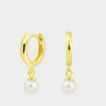Drop pearl huggies in 18k gold plated silver. The earrings feature a huggie-style design with drop-shaped pearls. The pearls are lustrous and elegantly suspended from the gold plated silver hoops. The hoops have a sleek and polished finish. These earrings are versatile and can be worn for both casual and formal occasions