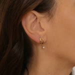  plain huggie hoops in 18k gold plated silver. The earrings feature a classic huggie-style design with a simple and sleek look. The hoops are made of high-quality gold plated silver and have a polished finish