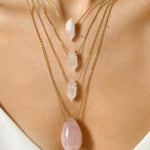 Rose Quartz crystal necklace. The first necklace features a pointed rose quartz crystal pendant, while the second necklace features a delicate gold paper clip chain. Together, the necklaces create a stunning layered look that adds sophistication and elegance to any outfit.
