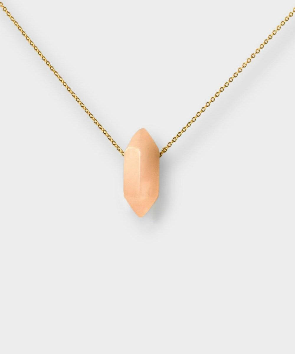 Rose quartz crystal necklace. The necklace features a pointed rose quartz crystal pendant  attached to a gold chain, creating a stunning and eye-catching piece of jewelry.