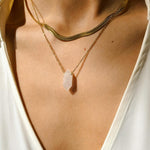 Rose Quartz crystal necklace. The first necklace features a pointed rose quartz crystal pendant, while the second necklace features a delicate gold snake chain. Together, the necklaces create a stunning layered look that adds sophistication and elegance to any outfit.