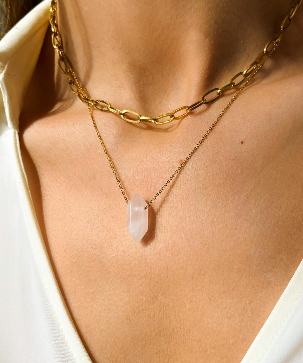 Rose Quartz crystal necklace. The first necklace features a pointed rose quartz crystal pendant, while the second necklace features a delicate gold paper clip chain. Together, the necklaces create a stunning layered look that adds sophistication and elegance to any outfit.