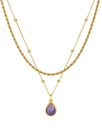 Amethyst teardrop pendant on a gold-tone beaded necklace layered with a separate rope chain on a white background.