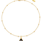 Gold necklace with a black teardrop pendant on a white background