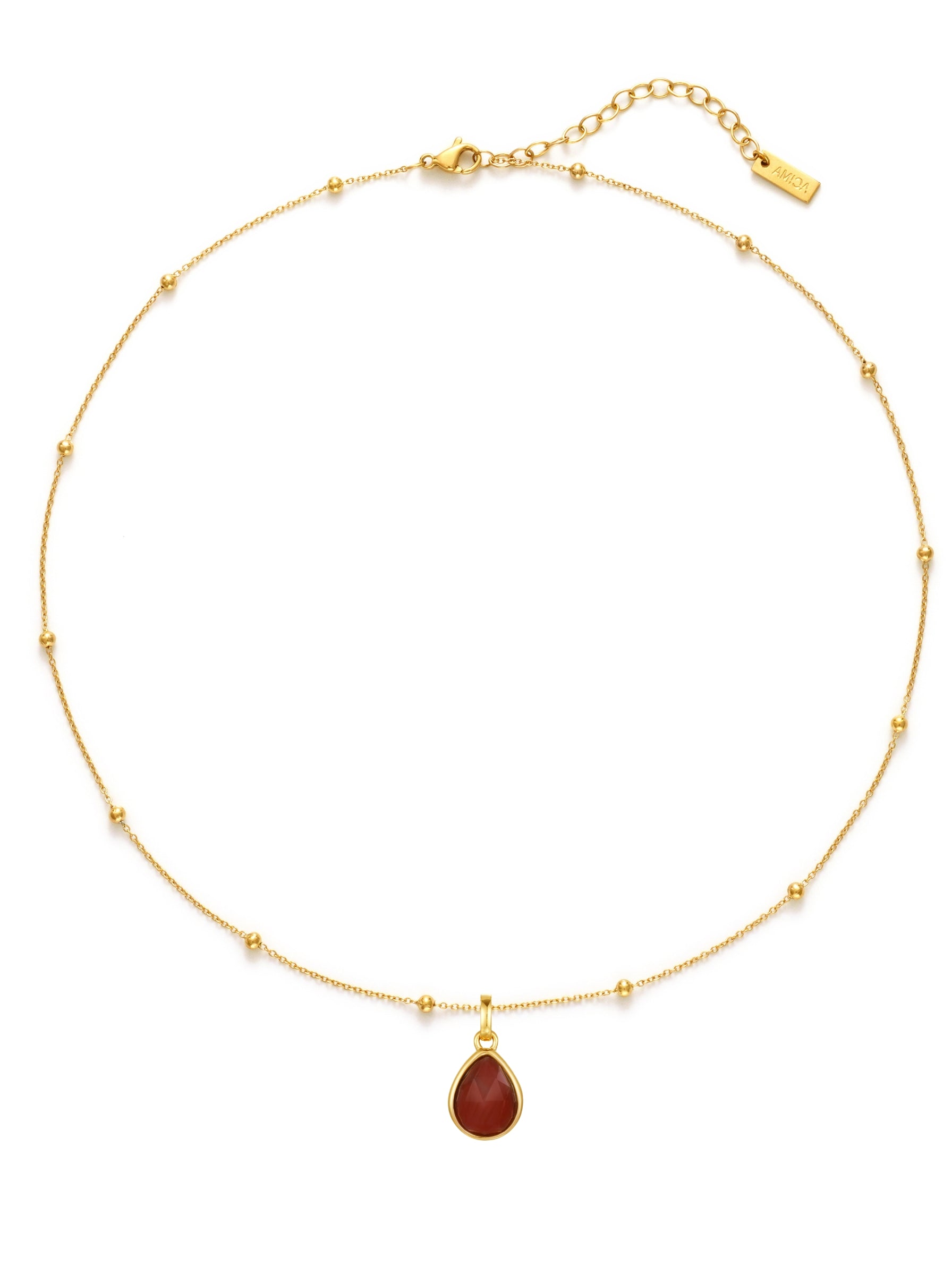 Gold necklace with a red teardrop pendant on a white background