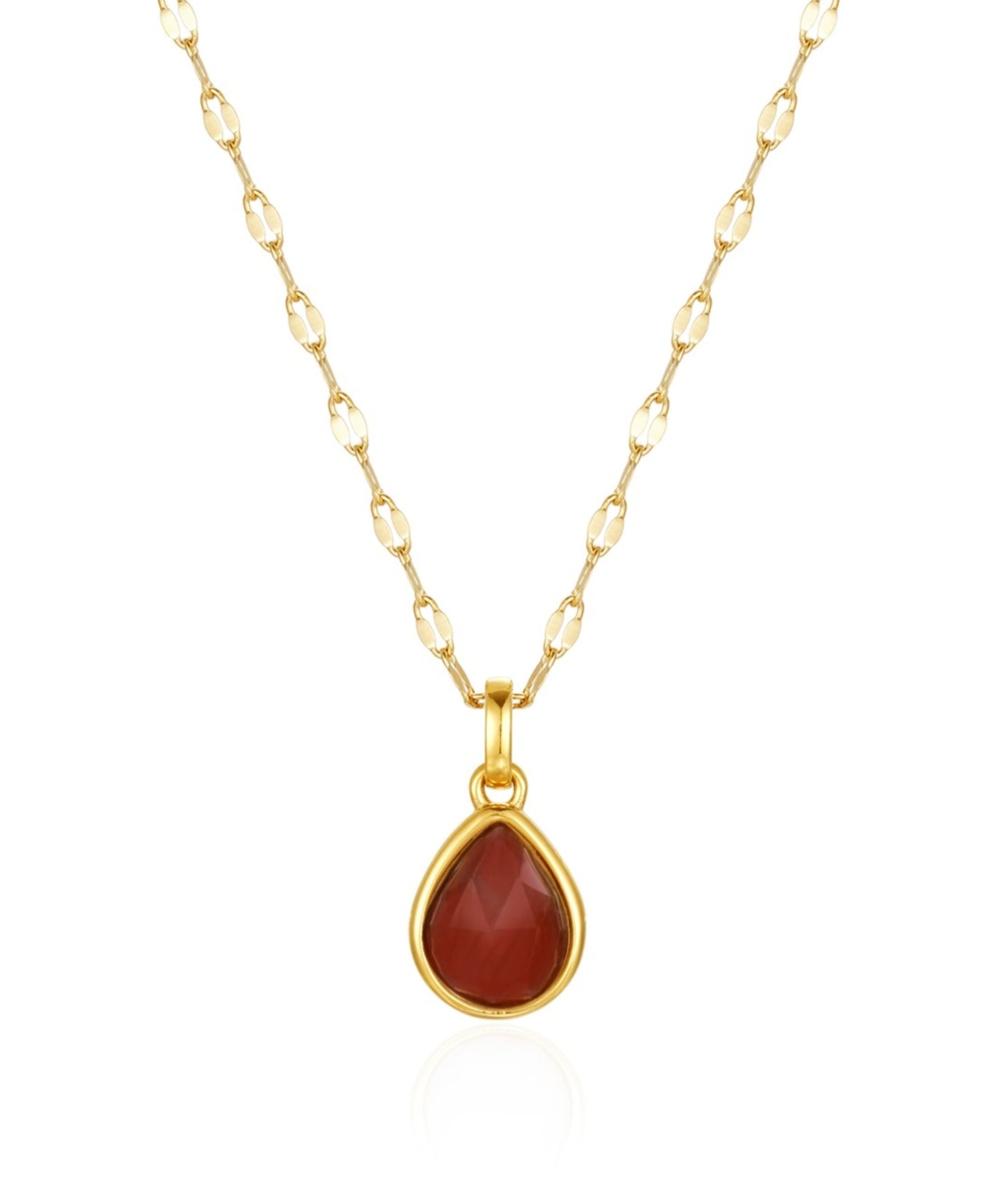 Gold necklace with a red teardrop pendant on a white background