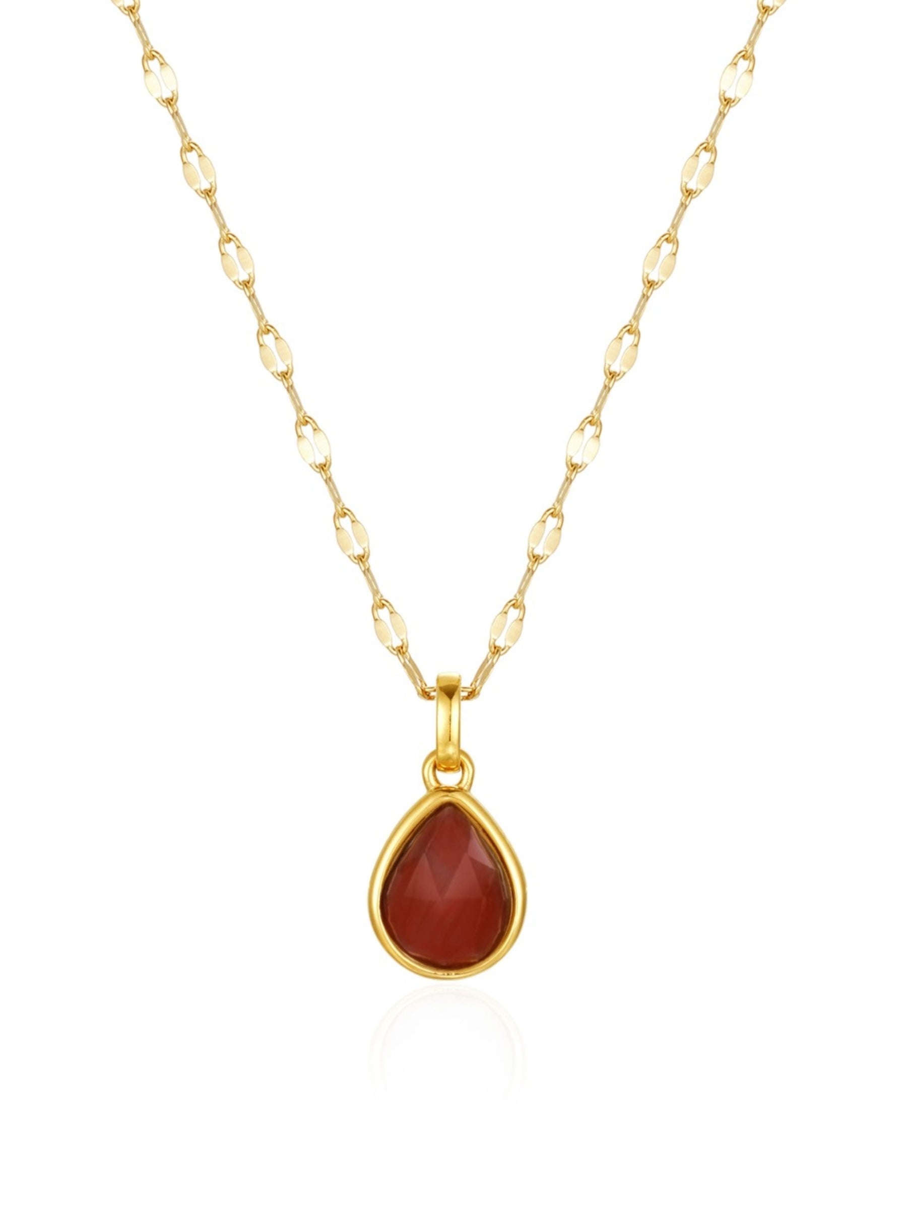 Gold necklace with a red teardrop pendant on a white background