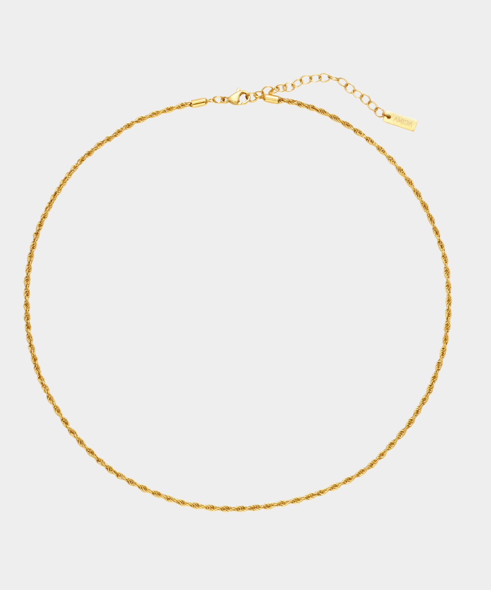Gold necklace on a light gray background