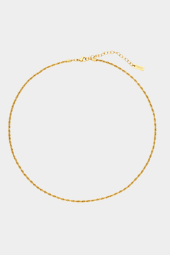Gold necklace on a light gray background