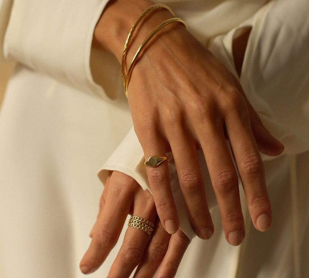 a 18k gold vermeil cuff bracelet with a round shape. The bracelet is made entirely of silver, with a smooth and polished finish. This versatile 18k gold vermeil cuff bracelet adds a touch of elegance and sophistication to any wrist.