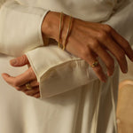 a 18k gold vermeil cuff bracelet with a round shape. The bracelet is made entirely of silver, with a smooth and polished finish. This versatile 18k gold vermeil cuff bracelet adds a touch of elegance and sophistication to any wrist.